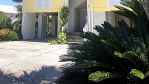 A yellow building with a white roof, a large window, and a staircase leading to the entrance. - Golf Cart, River and Marsh Views, Oceanfront Community, Beautiful Sunsets (St Helena Island)