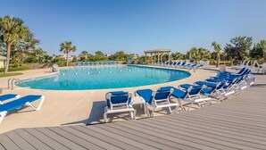 A poolside area with a clear blue pool, blue lounge chairs, and a wooden deck. - Golf Cart, River and Marsh Views, Oceanfront Community, Beautiful Sunsets (St Helena Island)