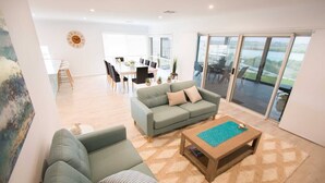 A spacious living area with a sofa, a coffee table, and a dining table set for six. - 'Serenity' and sweeping Murray River views (Tailem Bend)