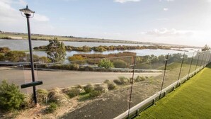 A view of a river with a bridge, a lamp post, and a grassy area. - 'Serenity' and sweeping Murray River views (Tailem Bend)
