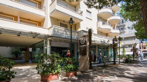 L’entrée d’un hôtel, avec un sol carrelé, des plantes en pot et une enseigne indiquant « Tulipano Residence ».