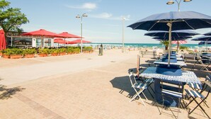 Un restaurant situé en bord de mer, avec une terrasse et des parasols, offrant une vue sur l’océan.
