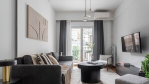 Ein modernes Wohnzimmer mit einer Couch, einem Couchtisch und einem Fernseher.