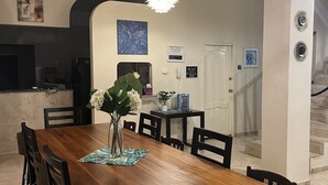 A dining area with a wooden table, chairs, a vase with flowers, a ceiling fan, and a hanging light fixture. - Large private villa with a pool and jacuzzi, close to the beach (Playas Villamil)