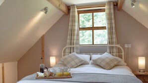 A bedroom with a bed, a window, a bedside table, and a tray with breakfast items. - 2 bedroom accommodation in Llechryd, near Cardigan (Llechryd, near Cardigan)