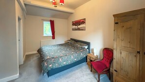 A bedroom with a bed, a chair, a wardrobe, a window, and a radiator. - 1 bedroom accommodation in Bowes, near Barnard Castle (Bowes, near Barnard Castle)