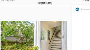 Un escalier menant à une porte sur laquelle on peut lire : « Je suis à la plage », ainsi qu’un panneau indiquant : « Douches 1, cabines 2 », et une affiche représentant la Nouvelle-Angleterre, accrochée au mur.