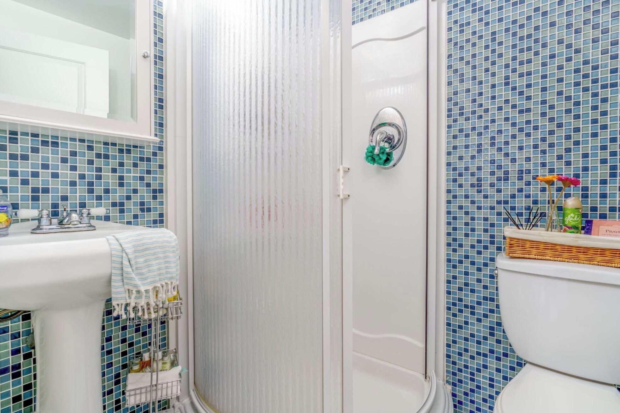 A bathroom with a shower, toilet, and sink.