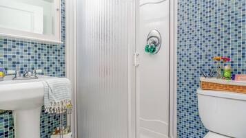 A bathroom with a shower, toilet, and sink.