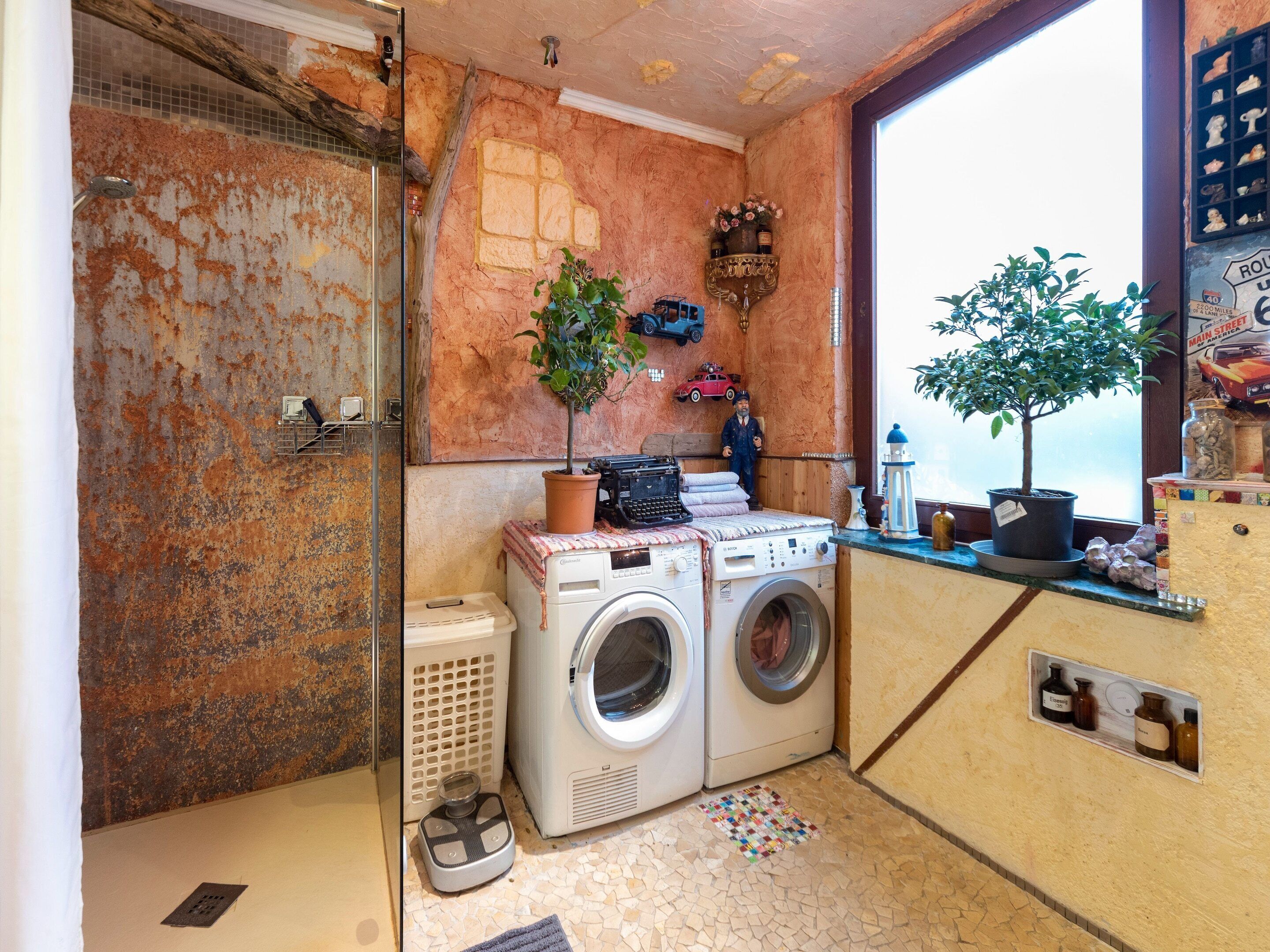 A compact laundry room with a washing machine, dryer, and a small sink.