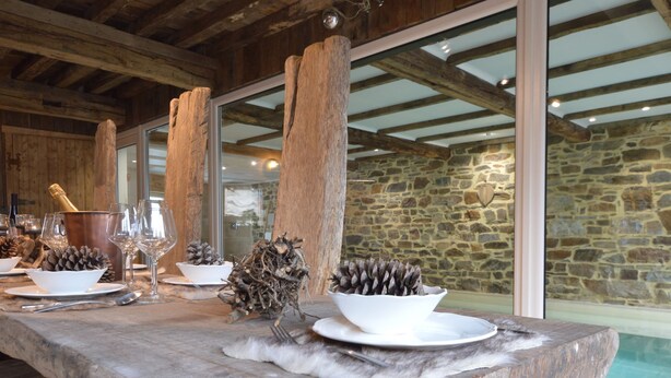 A stone counter with a rustic design, featuring a bottle of champagne, wine glasses, and decorative pinecones. - Country Home in Theux With Pool & Sauna (Theux)