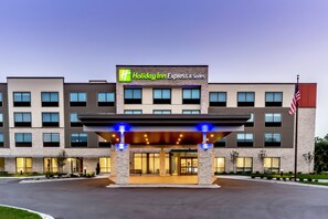 A Holiday Inn Express & Suites building with a modern facade, multiple windows, and an American flag. - Holiday Inn Express Milwaukee West Allis by IHG (Milwaukee)
