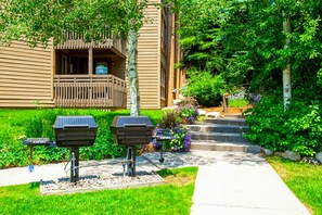 Enjoy a peaceful retreat with a balcony overlooking a lush garden featuring a variety of plants and flowers, perfect for outdoor cooking.