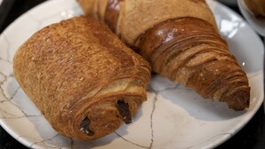 A tray with croissants, a bowl of fruit, and a glass of orange juice. - voco Edinburgh-Haymarket by IHG (Edinburgh)