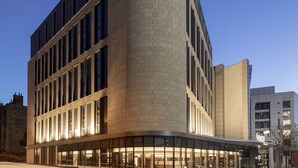 A modern building with a curved facade, large windows, and a well-lit entrance. - voco Edinburgh-Haymarket by IHG (Edinburgh)