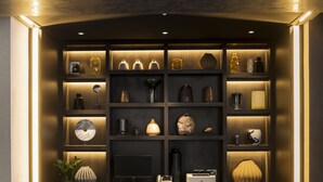 A modern, well-lit room with a dark wood desk, two chairs, and a variety of decorative items on shelves. - voco Edinburgh-Haymarket by IHG (Edinburgh)