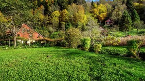 A rural landscape with a red barn, a small house, and a field of green crops. - Serene Holiday Home in Dolus With Private Garden (Brod Moravice)