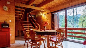 A wooden cabin interior with a dining area, a staircase, and a view of the outdoors. - Serene Holiday Home in Dolus With Private Garden (Brod Moravice)