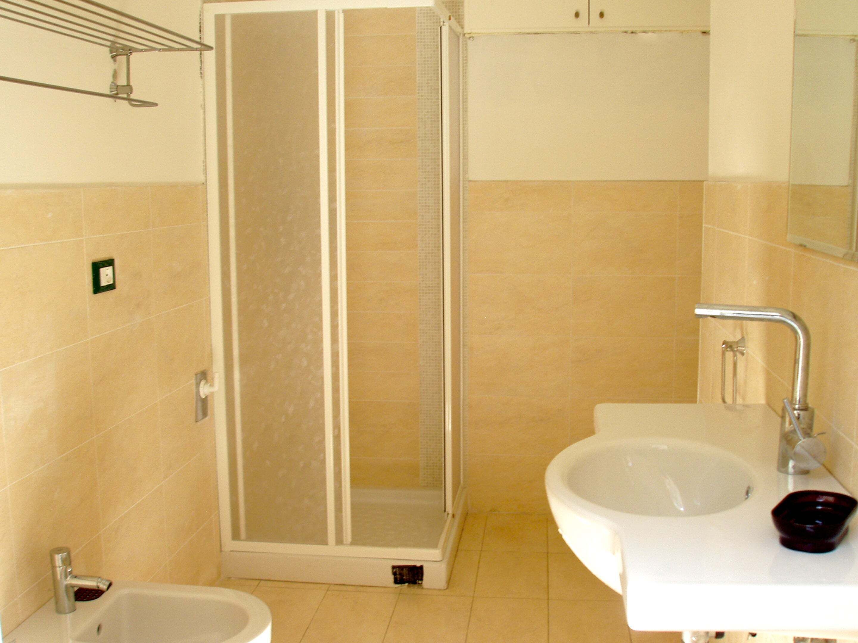 A bathroom with a shower, sink, and toilet.