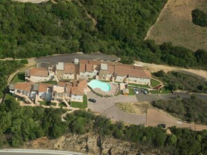 An aerial view of a residential area with multiple houses, a swimming pool, and surrounding greenery. - Holiday Home in Baja Sardinia Near Beach (Arzachena)