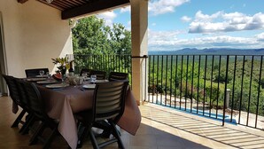 An outdoor dining area with a table set for four, surrounded by chairs, and a view of a mountainous landscape. - Courry Views: Pool & Nature (Courry)