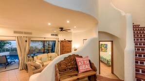 A cozy living area with a sofa, a wooden bench, and a ceiling fan. - Beachfront, Private Pool, close to Downtown San Jose (San Jose del Cabo)