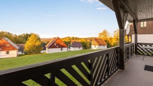 Un espace extérieur abrité offrant une vue sur les maisons et les arbres.