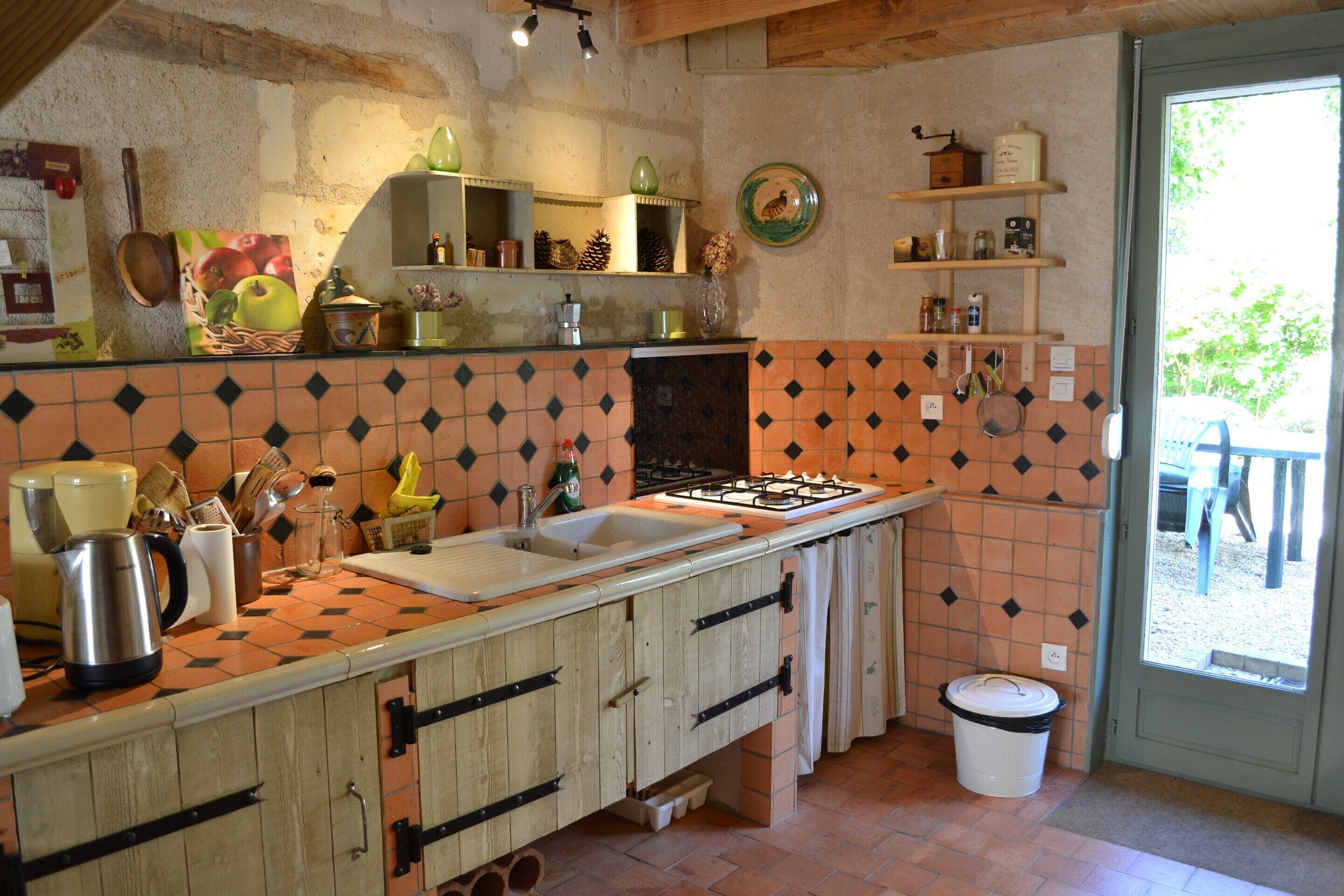 A kitchen with a tiled backsplash, wooden cabinets, a sink, and a window.