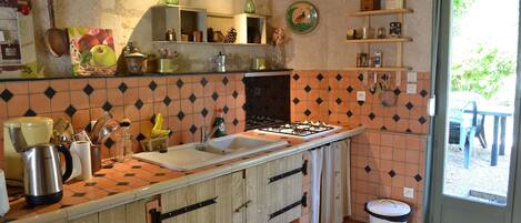 A kitchen with a tiled backsplash, wooden cabinets, a sink, and a window.