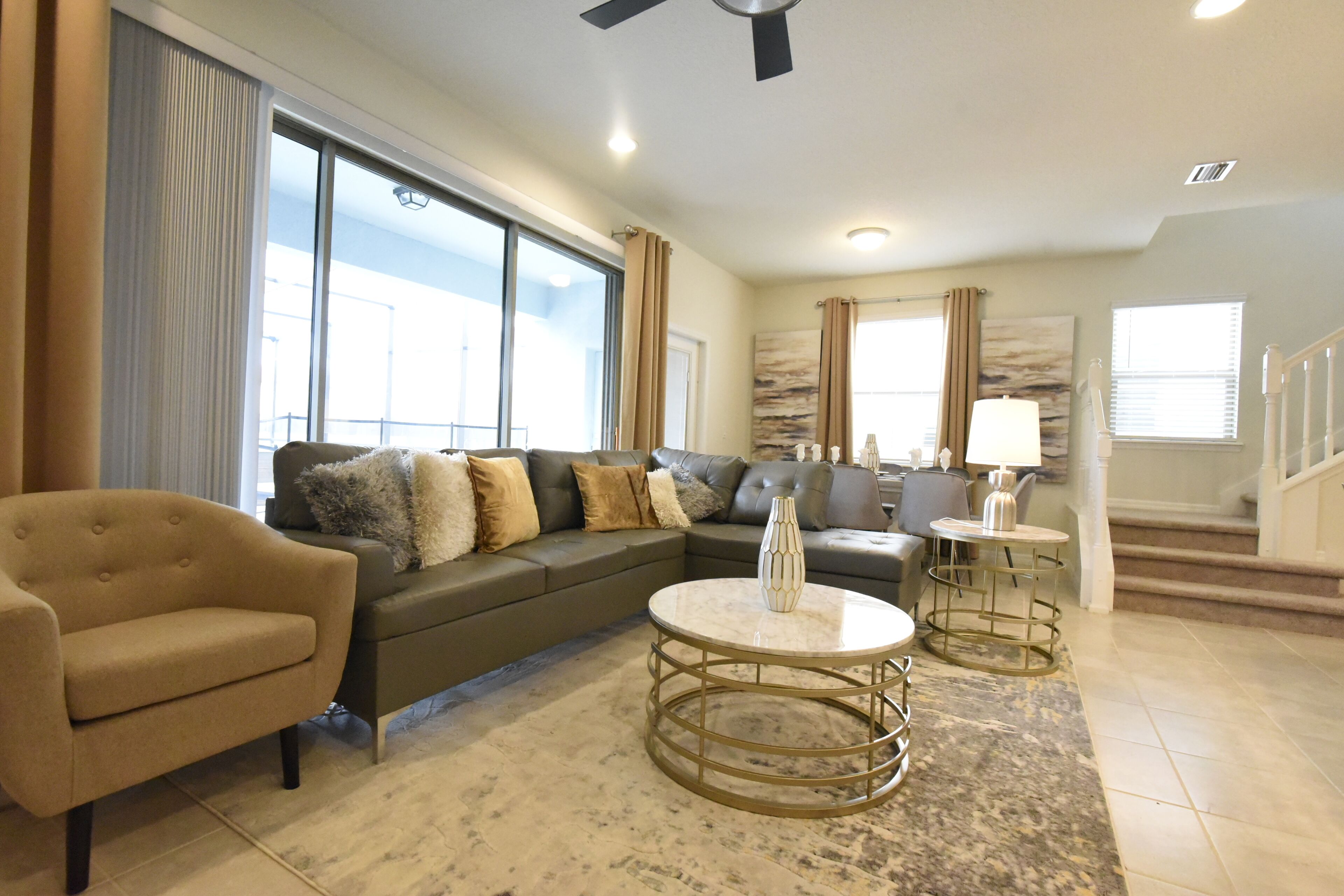 A spacious living room with a large sofa, a coffee table, and a lamp.