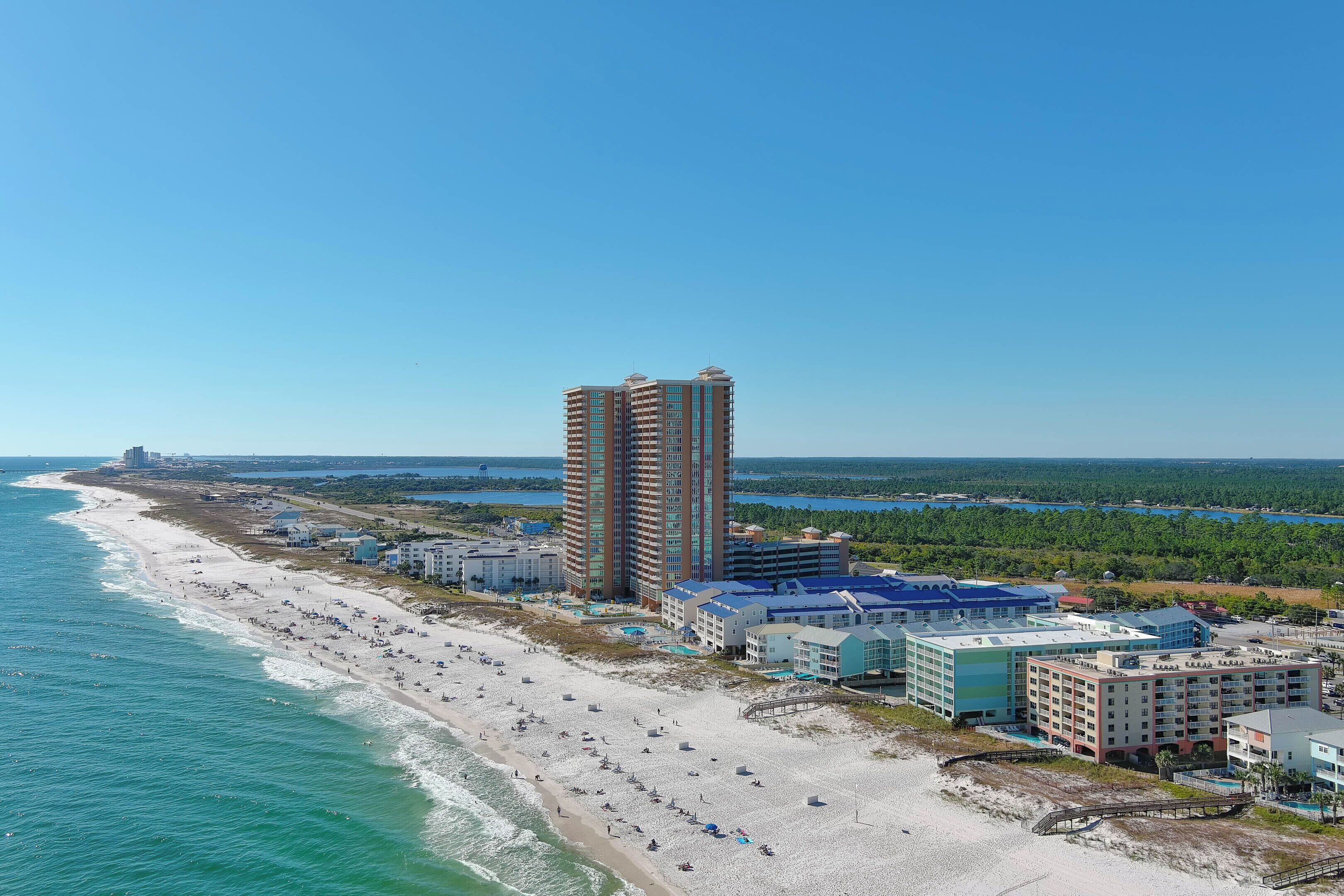 A coastal hotel with multiple buildings, a beach, and a view of the ocean.