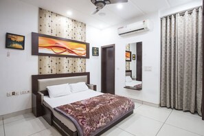 Enjoy a restful stay in this stylish room with a large bed, ceiling fan, and air conditioning unit.
