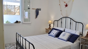 Une chambre à coucher comprenant un lit, deux tables de chevet, une fenêtre avec vue et un élément décoratif fixé au mur.
