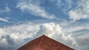 Ein pyramidenförmiges Gebäude mit rotem Dach, umgeben von einem bewölkten Himmel.