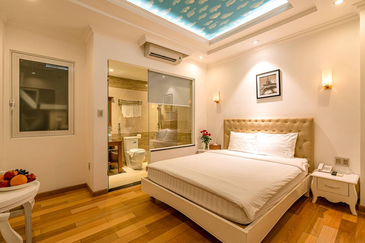 Une chambre d’hôtel moderne avec un grand lit, une salle de bain dotée d’une douche en verre et un plafond vitré.