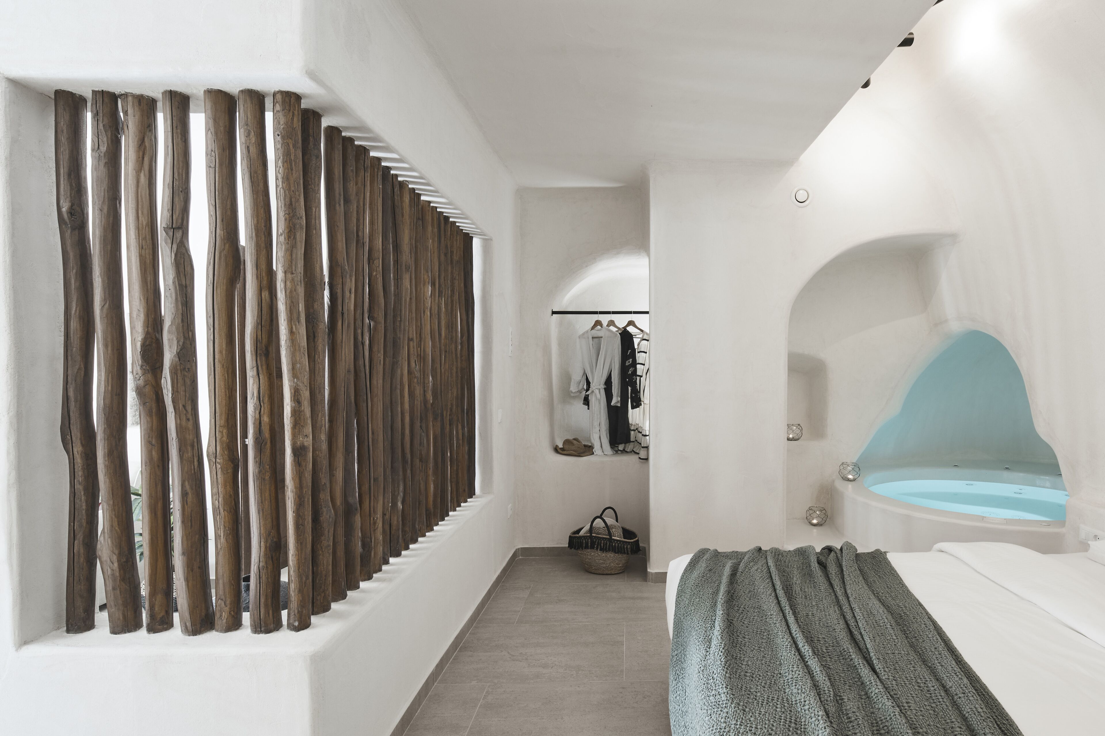 Une salle de bain moderne dotée d’une baignoire, d’un espace douche et d’un dressing ouvert avec des vêtements suspendus.