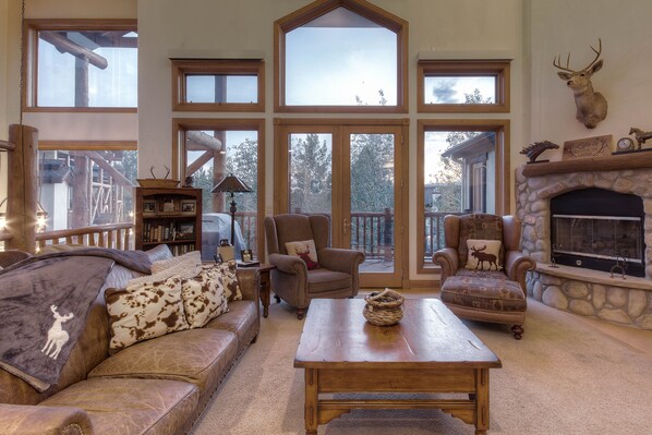 Relax in this inviting living room with a stone fireplace, comfortable armchairs, and a bookshelf filled with books.
