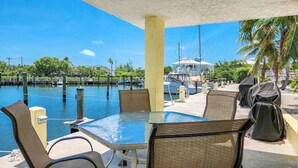 A covered outdoor seating area with a view of a marina and boats. - Fishing Till Sunset 1bed/1bath Condo w/Pool & dock (Marathon)