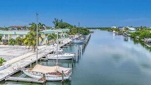 A marina with boats docked, a waterway, and buildings along the shore. - Fishing Till Sunset 1bed/1bath Condo w/Pool & dock (Marathon)