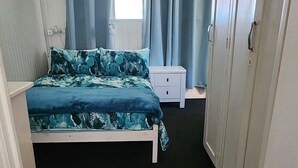 A bedroom with a bed, a wardrobe, a ceiling fan, and a window with curtains. - Meyenburg Unit 5, 2 Double Bed's 4 Pax (Mount Morgan)
