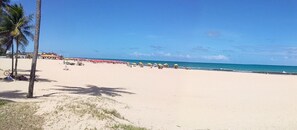 A beach with palm trees, umbrellas, and a clear sky. - Studio apartment in Recife's most upscale neighborhood (Pina)