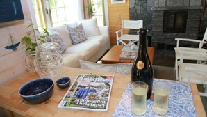 A cozy living room with a wooden table, a sofa, and a fireplace. - Seaside Villa with jacuzzi and own beach (Maksamaa (Vöyri))