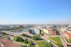 A cityscape with a river, modern buildings, and a highway. - Sky Hostel Helsinki (Helsinki)