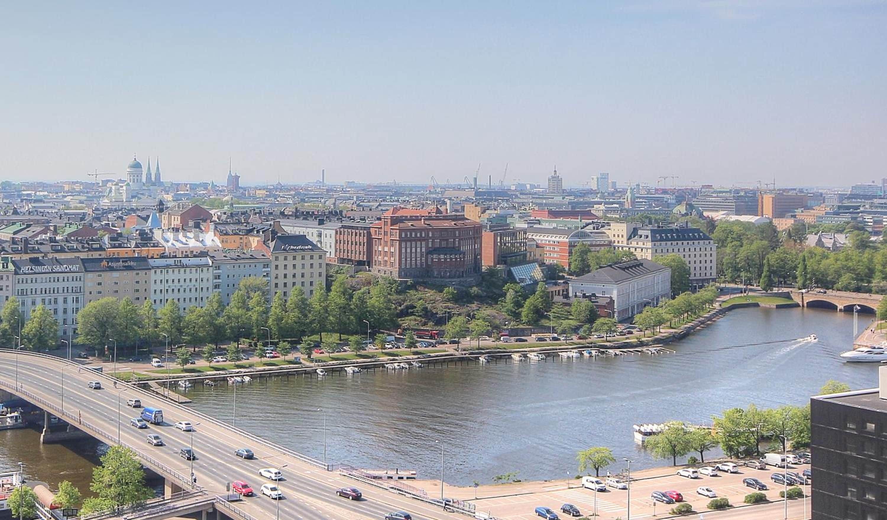 A cityscape with a river, bridges, and a mix of modern and historic buildings.