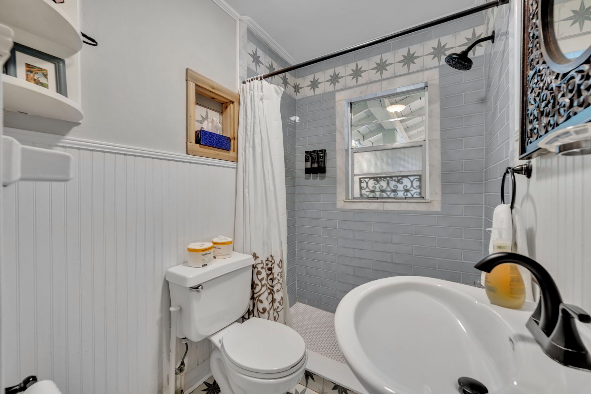 Et badeværelse med toilet, håndvask og bruser.