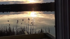 A view of a lake at sunset with reflections of the sky, surrounded by reeds. - Lakefront  Fall Foliage in New England Just 2 Hours From NYC (Sharon)