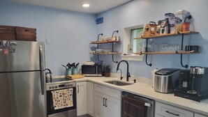 A modern kitchen with stainless steel appliances, white cabinets, and a wooden countertop. - Lakefront  Fall Foliage in New England Just 2 Hours From NYC (Sharon)