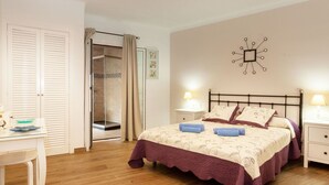 A bedroom with a bed, bedside tables, a desk, a shower, and a wall clock. - Beautiful  villa for 5 guests with WIFI, TV and balcony (Tossa De Mar)