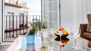 A balcony with a glass table, potted plants, and a fruit bowl. - Beautiful  villa for 5 guests with WIFI, TV and balcony (Tossa De Mar)