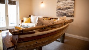 Una cama con forma de barco en una habitación con un cuadro en la pared y una puerta que da al exterior.